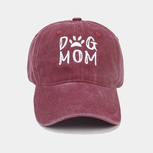 Detailed view of white DOG MOM embroidery and paw print on washed cotton baseball cap
