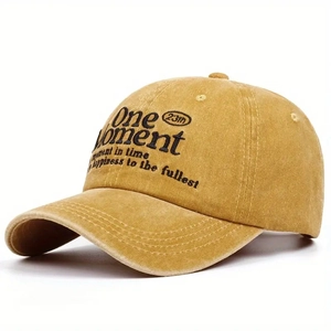 Detail view of yellow washed cotton baseball cap with One Moment embroidery lettering