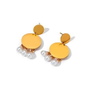 Detailed macro view of gold metallic irregular discs with white teardrop pearl accents