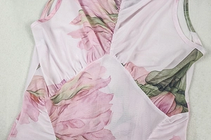 Detail of pink floral dress featuring elegant V-neckline and refined pleated texture
