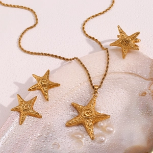 Starfish pendant necklace and jewelry set on a seashell with water drops