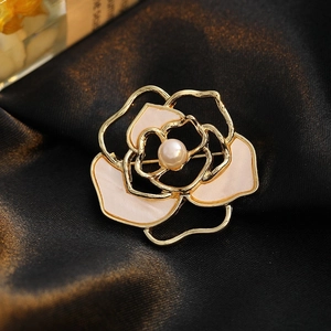 Elegant gold camellia flower brooch with cream enamel and a central pearl accent