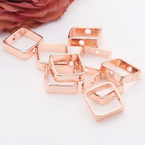 Macro shot of 14K gold filled square bead frames with side holes for DIY jewelry