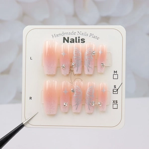 Détail de faux ongles papillon argentés avec dégradé pailleté et accents de strass