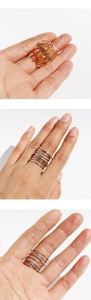Close-up of multilayer spiral spring rings in gold and silver finish on hand