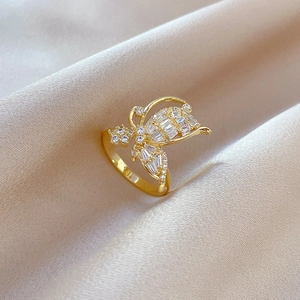 Detail of gold bow ring with cubic zirconia on champagne silk background