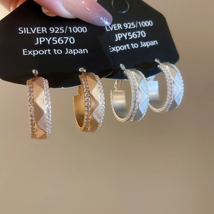 Dettaglio macro di orecchini a cerchio in argento S925 placcato oro 18k con zirconi
