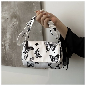 Detail of white butterfly print crossbody bag with magnetic snap and adjustable strap