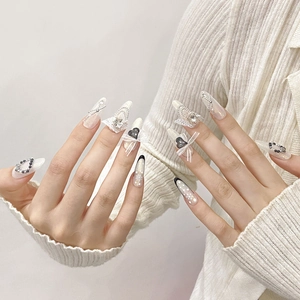 Handmade stiletto press-on nails with white lace bows, black hearts, and pearl chains