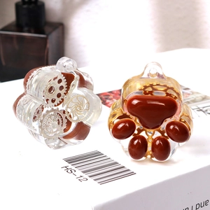Detailed macro view of cat paw resin pendants with internal gear components and top hanging holes