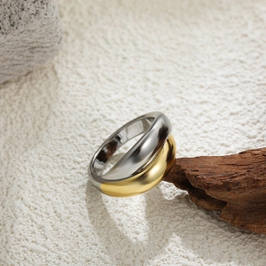 Macro shot of two-tone 18K gold and silver wide band ring on textured rustic surface