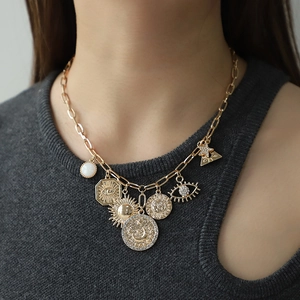 Gold chunky necklace with sun, moon, and eye pendants featuring sparkling zircon accents