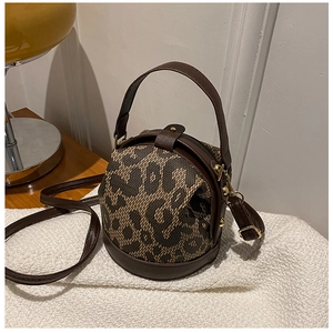 Detail of leopard print patchwork barrel bag with brown leather on white faux fur