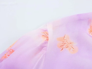 Detail of purple floral chiffon blouse showing shoulder seams and lightweight fabric texture
