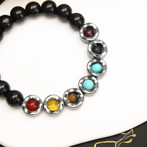 Macro shot of tiger eye beads and colorful inlaid gemstones on a yoga wave bracelet