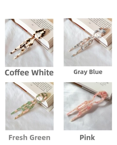Macro detail of U-shaped acetate hair pins in marble patterns and four elegant colors
