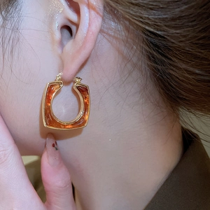 Close-up of vintage square resin hoop earrings with 18k gold plating on model