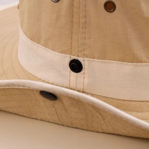 Detail of khaki sun hat with ripstop fabric texture, metal buttons and metal eyelets
