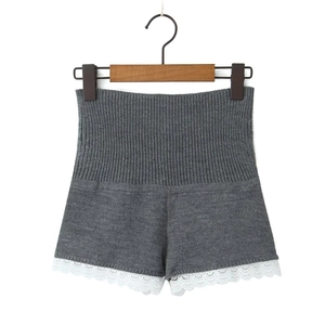 Détail du short en maille gris foncé à taille haute avec bordure en dentelle blanche