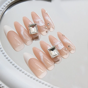 Long almond press-on nails with light pink waves, French tips and luxury rhinestones