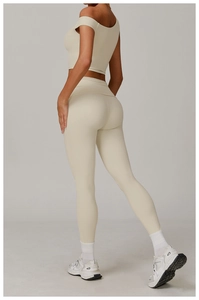 Détail du legging de yoga taille haute crème montrant le tissu élastique et le galbe du corps