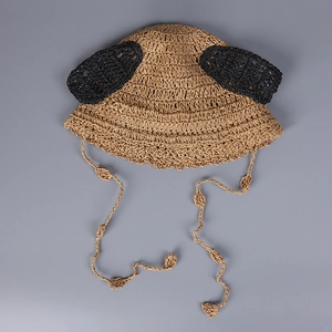Detailed knit texture of a handmade straw sun hat with cute ears and chin straps