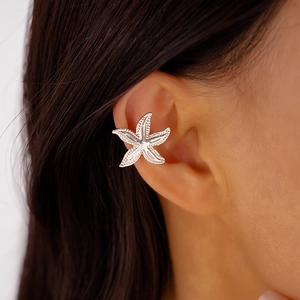 Close-up of a silver starfish-shaped ear cuff on a model showing metallic texture