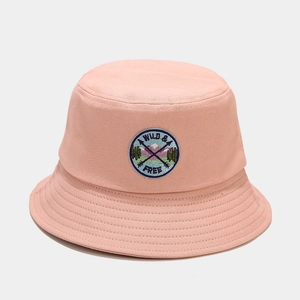 Detailed view of pink cotton bucket hat featuring a circular mountain embroidery patch