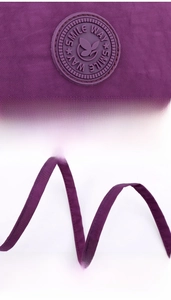 Detail of a purple nylon bag featuring a round SMILE WAY logo and durable shoulder strap