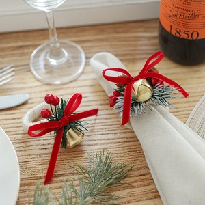 Christmas napkin ring with gold bell, red bow, pine needles and berries for table decor