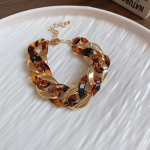 Close-up of leopard print resin and gold chain links on a stylish fashion bracelet