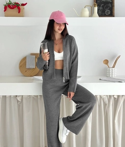 Detail of grey knitted two-piece set featuring a zipper cardigan and high waist wide-leg pants