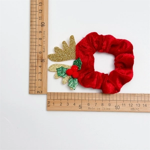 Chouchou de Noël en velours rouge avec bois dorés et cloches sur fond blanc pur