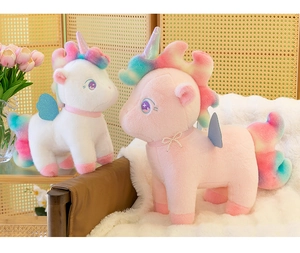 Close-up of two plush unicorns in white and pink with rainbow manes and blue wings