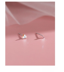 Macro detail of S999 sterling silver heart-shaped iridescent cubic zirconia stud earrings