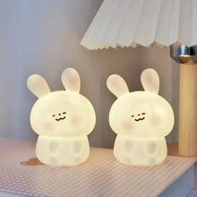 Close-up of glowing bunny night lights on a book with soft warm lighting for bedroom decor