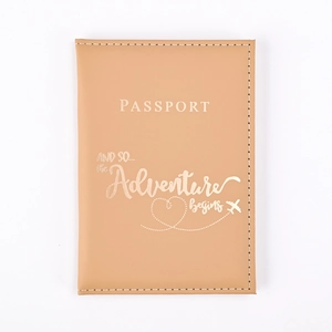 Close-up of light brown PU leather passport cover with gold embossed adventure quote