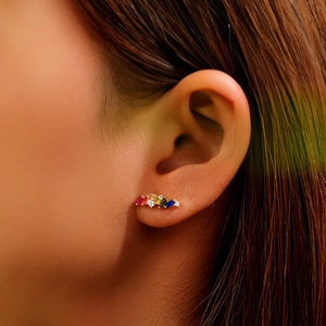Detail of colorful baguette-cut rainbow cubic zirconia studs on a golden setting