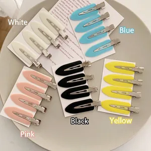 Five sets of seamless colorful duckbill hair clips on a ceramic tray for styling