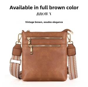 Close-up of brown PU leather bag with golden zippers and a woven geometric shoulder strap