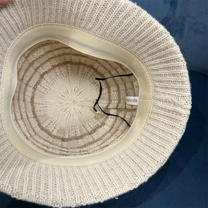 Detail of knitted bucket hat interior showing the adjustment strap and stitch texture