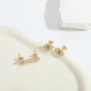 Golden evil eye and fish stud earrings set with white and blue cubic zirconia stones