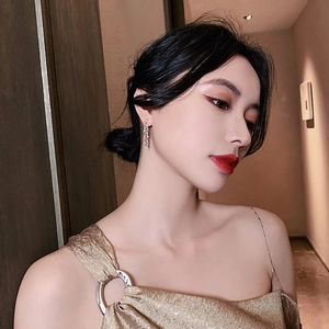 Gros plan d'une boucle d'oreille feuille de blé argentée avec glands sur un mannequin