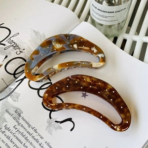 Detail of tortoise shell and amber marble acetate hair claws with sparkling rhinestones