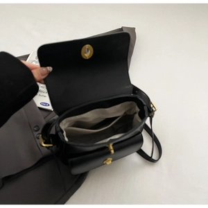Internal view showing light-colored lining and interior pocket of the black messenger bag