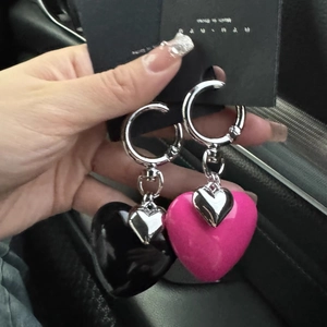 Close-up of pink and black resin heart keychains with metal rings on card holder