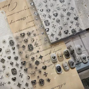 Detail of gothic embossed nail stickers with gold and silver cross and heart designs
