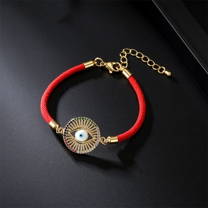 Détail macro du bracelet Evil Eye en cordon rouge avec dorure et cristaux pavés colorés