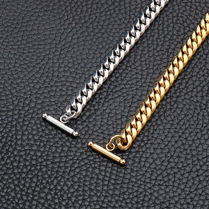 Detail of gold and silver Cuban link bracelets with OT buckle on black leather
