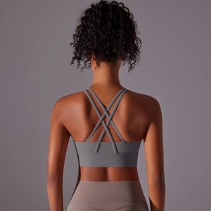 Dettaglio delle spalline incrociate del reggiseno sportivo grigio con fascia larga